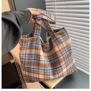 Close-up of retro plaid wool tote bag with magnetic snap button and soft fabric texture