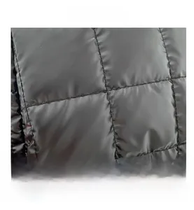 Close-up of black quilted puffer tote bag fabric showing glossy water-resistant texture