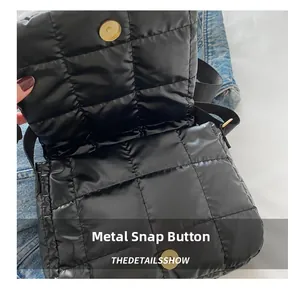 Detail of black quilted shoulder bag featuring a secure golden magnetic snap closure