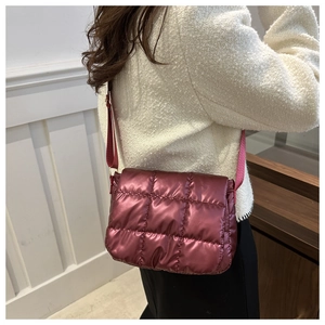 Borsa a tracolla trapuntata bordeaux con cinturino largo indossata da una modella