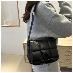 Borsa a tracolla nera trapuntata vista laterale su modella in un ambiente accogliente