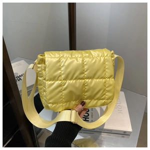 Dettaglio di una borsa trapuntata giallo brillante con fibbie dorate e tracolla larga