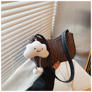 Detail der Hahnentritt-Unterachseltasche mit einem niedlichen weißen Wolkenanhänger