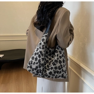 Close-up of plush leopard print faux fur texture and dark leather strap of the tote bag