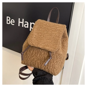 Close-up of brown plush backpack featuring lamb wool texture and leather strap detail