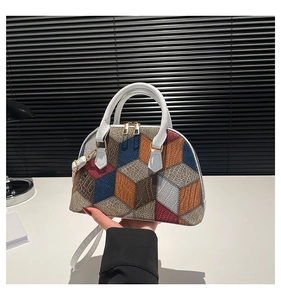Detailed close-up of geometric 3D pattern and gold metal hardware on shell handbag