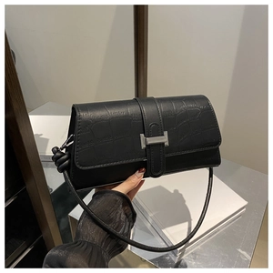 Detail of black crocodile texture bag featuring a silver rectangular metal buckle clasp