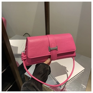 Close-up of pink croc-embossed leather handbag with elegant silver buckle and thin strap