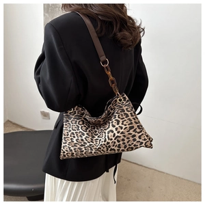 Detalle de bolso de hombro con estampado de leopardo y cadena de resina en modelo