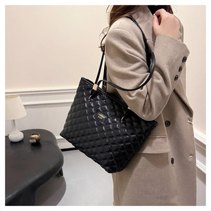 Detail of black quilted tote bag with polished finish and Fashion Bags metallic logo