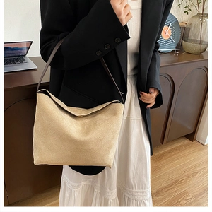 Détail du sac hobo en daim beige avec bandoulière en cuir marron et fermoir magnétique
