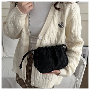 Detail of black pleated cloud bag with metallic chain and drawstring closure