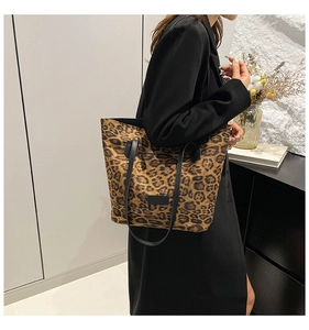 Detailed view of fashionable leopard print tote bag with black straps in modern interior