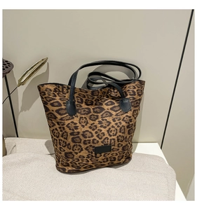 Detail of leopard print tote bag featuring black handles and a sleek black label patch