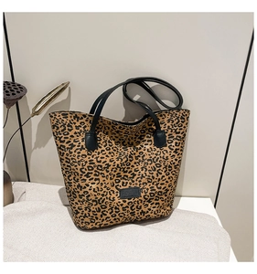 Macro shot of stylish leopard print tote bag with black handles on a minimalist background