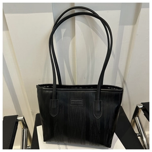 Detailed view of the black tote bag featuring wave textures and a Fashion Bag logo label