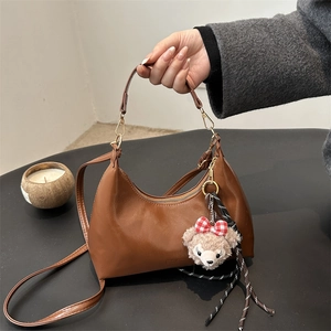 Dark brown oil wax leather hobo bag with teddy bear charm and adjustable shoulder strap