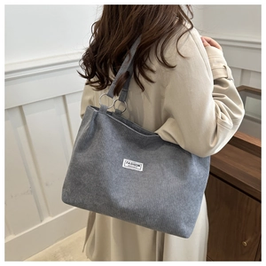 Detail view of grey corduroy tote bag with Fashion Instinct label and metal ring buckle