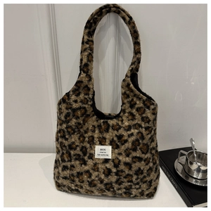 Detail shot of leopard print plush tote bag with fabric label and soft faux fur texture
