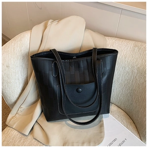 Detail of black woven tote bag with white contrast stitching and outer button pocket