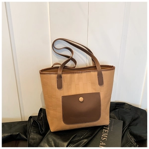 Detail of light brown tote bag with geometric brick texture and dark brown snap pocket