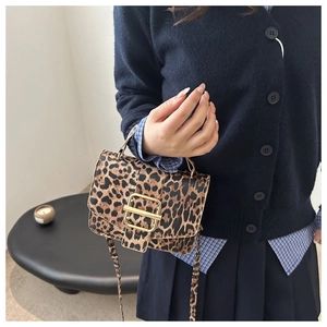 Sac à main léopard chic avec boucle dorée porté par un mannequin dans un style collège tendance