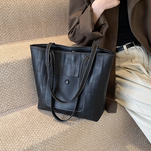 Large black woven leather tote bag with white contrast stitching for professional commuting