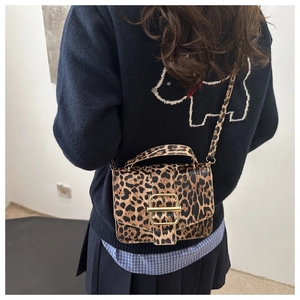 Gros plan du sac bandoulière léopard avec fermoir doré et texture raffinée