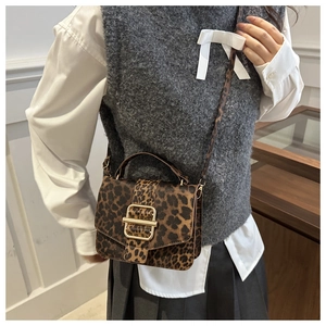 Détail du sac bandoulière léopard avec boucle dorée et texture élégante en cuir PU