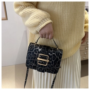 Sac bandoulière imprimé léopard porté avec un pull doux et une jupe plissée