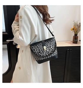 Detail view of stylish leopard print bucket bag featuring a secure gold press lock closure