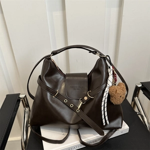Deep brown vintage tote bag in glossy leather with belt detail and plush bear charm