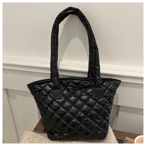 Close-up of black quilted tote bag with shiny nylon finish and classic diamond pattern