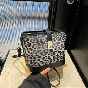 Modern leopard print bucket bag with black leather trim and gold metal clasp