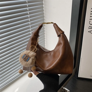 Brown leather half-moon hobo bag with gold metal buckle and cute lion pendant