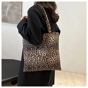 Detailed view of the large leopard print tote bag paired with a classic black trench coat