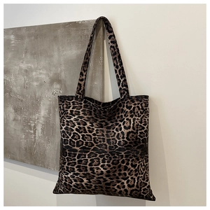 Detailed view of the leopard print canvas fabric and sturdy shoulder straps on the tote bag