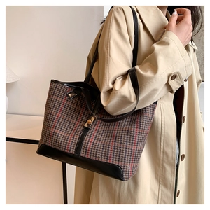 Detail of vintage plaid tote bag with classic weave texture and golden lock clasp