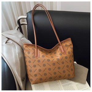 Detail of a large brown leather tote bag with vintage monogram and slim shoulder straps