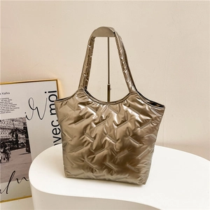 Dettaglio della borsa tote trapuntata color oro champagne con finitura lucida