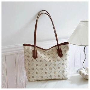 Detailed view of patterned tote bag featuring brown leather straps and beige PU texture