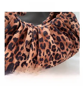 Macro view of leopard print handbag featuring pleated texture and velvet fabric detail