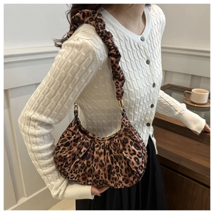 Detail of leopard print crescent bag featuring a stylish ruched scrunchie shoulder strap