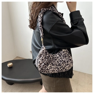 Detailed macro view of retro leopard print suede texture on stylish crescent hobo bag