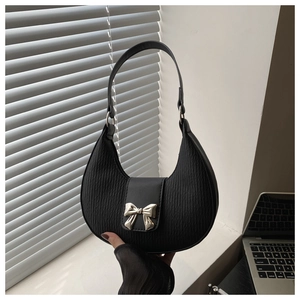 Close-up of pleated black shoulder bag featuring a silver metal bow buckle detail