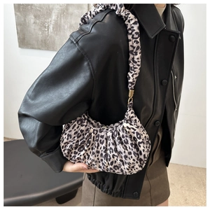 Detailed side view of leopard print crescent bag with a trendy scrunchie shoulder strap