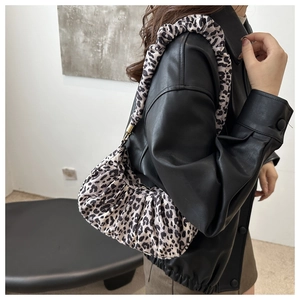 Detail view of leopard print ruched underarm bag with scrunchie shoulder strap on model