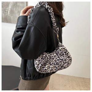 Detail of hobo bag featuring leopard print fabric, pleated texture and metal strap rings