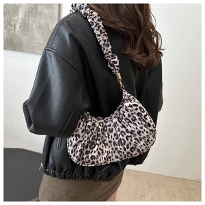 Detailed view of leopard print pleated underarm bag with scrunchy strap and metal buckle
