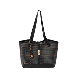 Large houndstooth tote bag with black leather trim and gold twist lock on white background